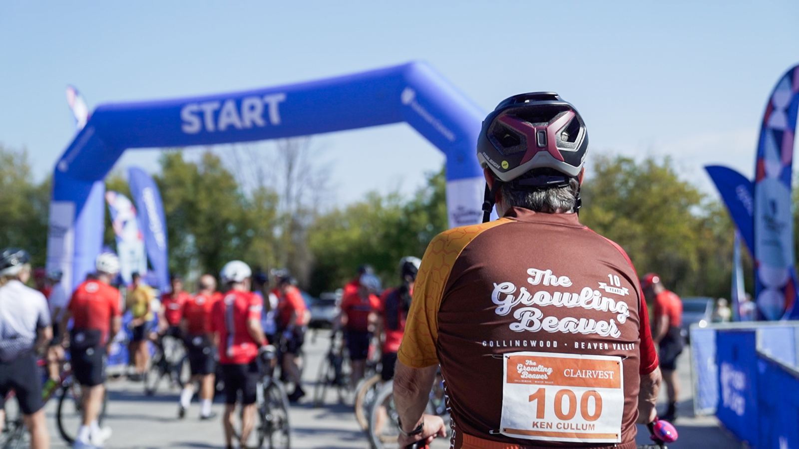 Rider in a 10-year Growling Beaver jersey facing the start arch