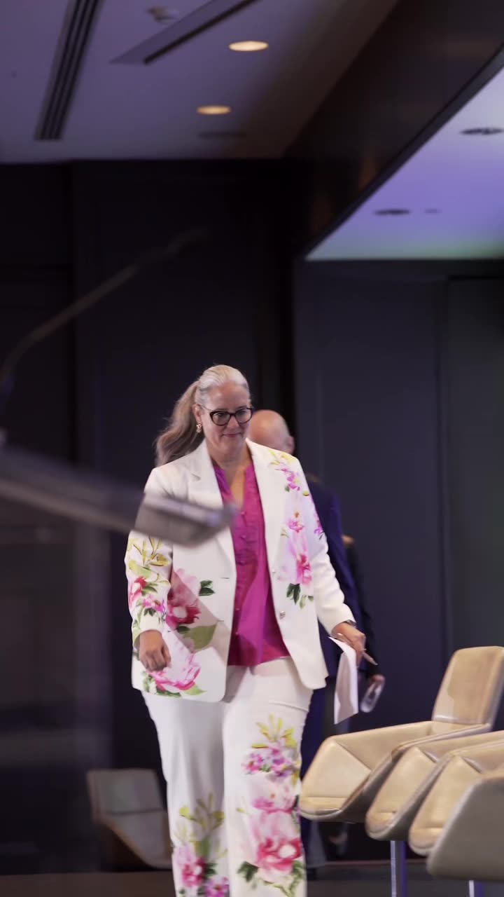 Speaker in a floral suit walking to the stage at the Quebec Hotel Investment Conference